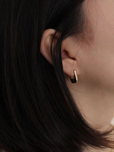 Orecchini a U in argento S925 dorato con smalto nero indossati da una modella elegante