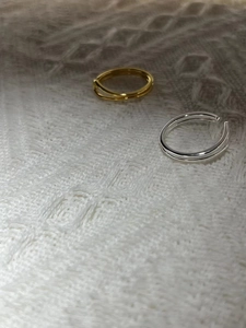 Detail of minimalist 925 sterling silver dual-layer open rings in gold and silver finish