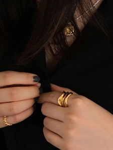 Irregular gold wave open ring and beaded band set worn by a model in close-up shot