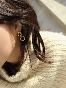 Detail of 925 sterling silver golden double-hoop earrings with textured metal finish