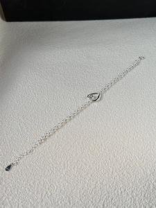 Close-up of S925 sterling silver bracelet showing heart pendant and hallmark stamp