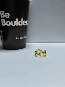Detailed macro view of the gold hollow chain link ring with a polished mirror finish