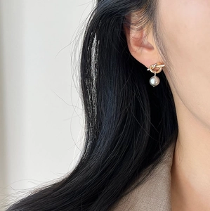 French style knotted gold earrings with lustrous silver grey pearls on female model