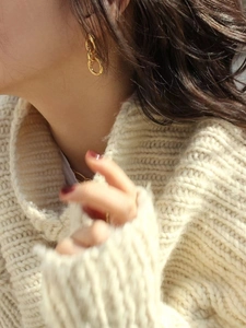 Detail of 925 sterling silver golden triple-link chain earrings with twisted texture on model
