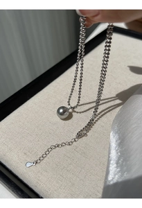 Detailaufnahme einer Silberperlenkette mit einem glänzenden grauen Perlenanhänger