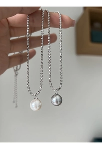 S925 Sterling Silber Kugelkette mit weißen und grauen Perlenanhängern in der Hand