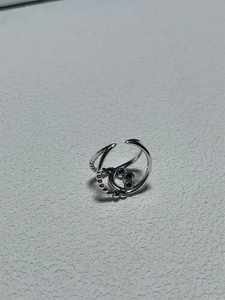 Close-up of a 925 sterling silver woven ring with hollow loop and beaded details