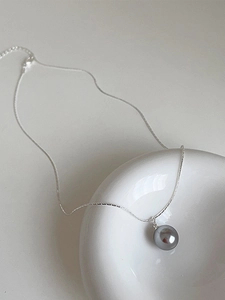 Minimalist 925 sterling silver necklace featuring a dark grey pearl pendant on ceramic