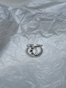 Detailed close-up of 925 sterling silver woven ring with beads on wrinkled paper