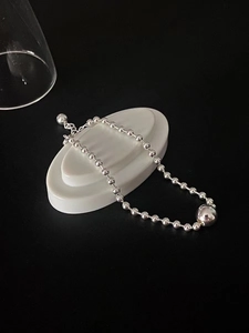 Detail of 925 sterling silver beaded bracelet with polished center ball and lobster clasp