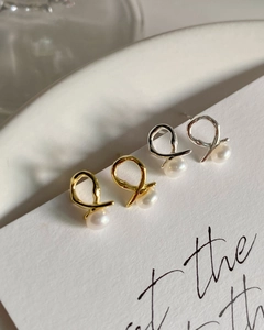 Macro view of 925 silver and gold crossover stud earrings with natural freshwater pearls