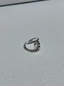 Macro detail of S925 sterling silver woven ring with bead accents and cross design