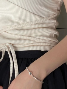 Detailed view of S925 sterling silver beaded bracelet with large sphere on wrist