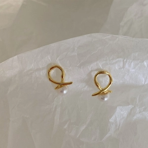 Close-up of minimalist 925 silver gold-plated irregular hoop earrings with natural pearls