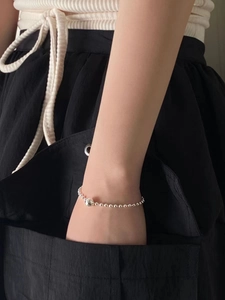 Minimalist 925 sterling silver beaded bracelet showing a polished focal ball on a wrist