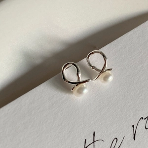 Detailed close-up of S925 sterling silver twist stud earrings with elegant natural pearls