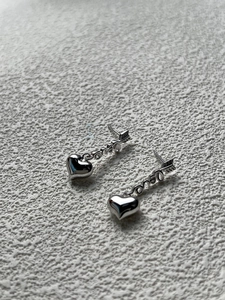 Detailed macro view of 925 sterling silver heart earrings featuring love letter design