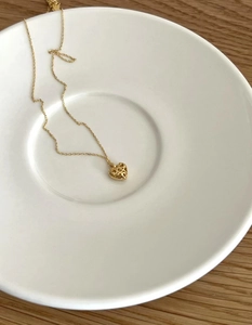 Gros plan d'un collier en argent 925 avec pendentif cœur filigrane sur assiette