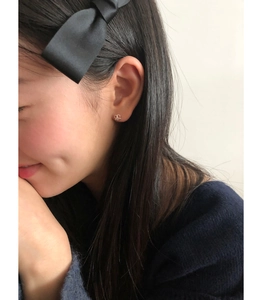 Close-up of minimalist 925 sterling silver hollow heart stud earrings on model's ear