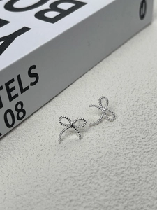 Vue détaillée de boucles d'oreilles nœud en argent 925 avec texture perlée fine