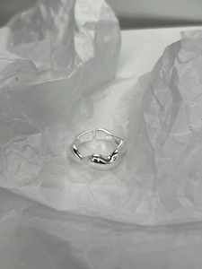 Macro shot of S925 hallmark on irregular wavy silver ring with molten lava texture