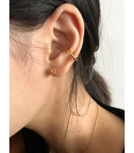Close-up of 925 silver gold-plated cross ear cuff and bow knot stud earring on model