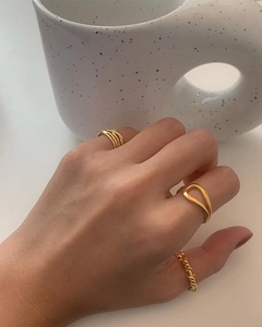 Three-piece gold plated ring set featuring minimalist knot and twisted band on a model