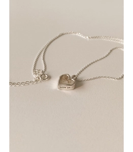 Detailed close-up of hollow heart pendant with Love ya engraving on silver chain
