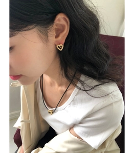 Detail view of 925 silver golden heart stud earrings and necklace on a female model
