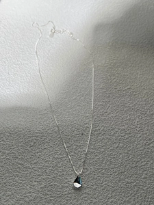 Macro view of minimalist S925 silver water drop pendant and mirror polished box chain