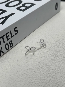Élégantes boucles d'oreilles nœud en argent sterling 925 avec texture perlée sur fond gris