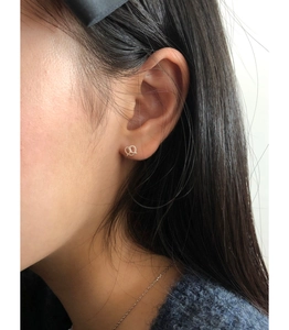 Close-up of minimalist 925 sterling silver pretzel knot stud earrings on ear