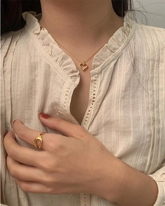 Elegant gold heart pendant necklace and irregular open ring set on a model