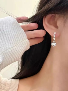 Polished S925 silver love heart earrings with arrow through love script on female model