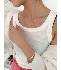 Collier en argent 925 avec croix et bracelet cœur portés par un mannequin femme