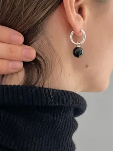 Créoles S925 en argent vintage avec perle d'onyx noire portées par un mannequin
