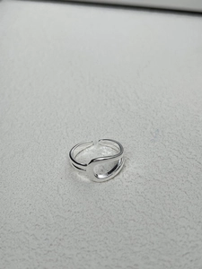 Macro view of minimalist 925 sterling silver knotted ring with polished wavy layers