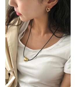 Detailed view of model wearing a 925 silver heart necklace and hollow heart earrings
