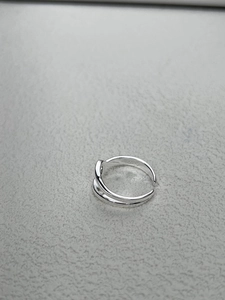 Detailed macro view of S925 sterling silver stamp on minimalist knotted open ring