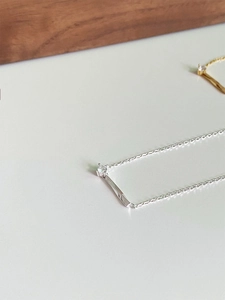 Détail macro du collier en argent s925 avec pendentif barre fine et petite pierre zircon