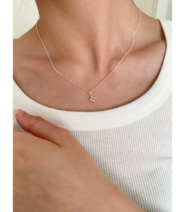 Collier avec pendentif croix perlée en argent sterling 925 porté sur la clavicule