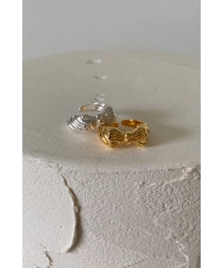 Detail view of gold and silver S925 sterling silver bow rings with textured relief finish
