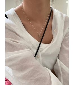 Collier en argent sterling 925 avec croix perlée porté sur une chemise en lin blanc