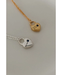 Détails de pendentifs cœur en or et argent avec pierres bleues et gravures gravées