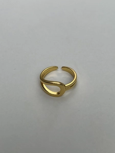 Detail view of the hollow curved surface and gold finish of the knot open ring