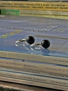 Boucles d'oreilles minimalistes en agate noire et argent sur magazines de design