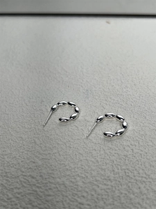 Detail of C-shaped S925 sterling silver hoop earrings with bead-style textured link design