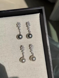 Macro detail of S925 silver pearl drop earrings with sparkling zircon clusters