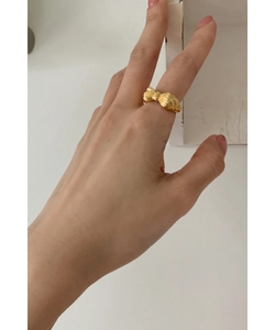 Close-up of a 925 sterling silver bow ring in gold finish worn on index finger