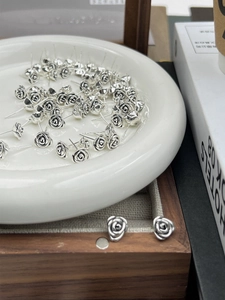 Detailed macro view of vintage 925 sterling silver rose earrings with black oxidation